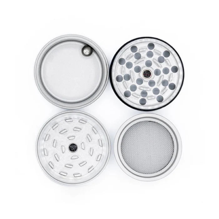Draufsicht auf die vier Einzelteile eines silbernen Edelstahl-Grinders, inklusive Mahlzähnen, Sieb und Auffangschale.