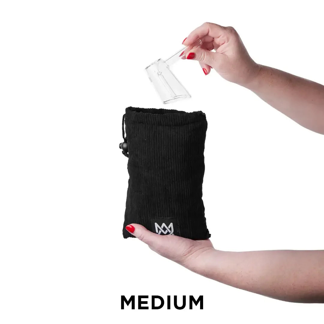 Eine Person legt ein Glas-Accessoire in einen schwarzen Cordbeutel der Größe „Medium“.