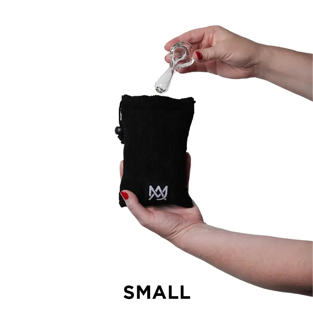 Eine Person hält eine kleine Glaspfeife über einen kompakten, schwarzen Cordbeutel der Größe „Small“.