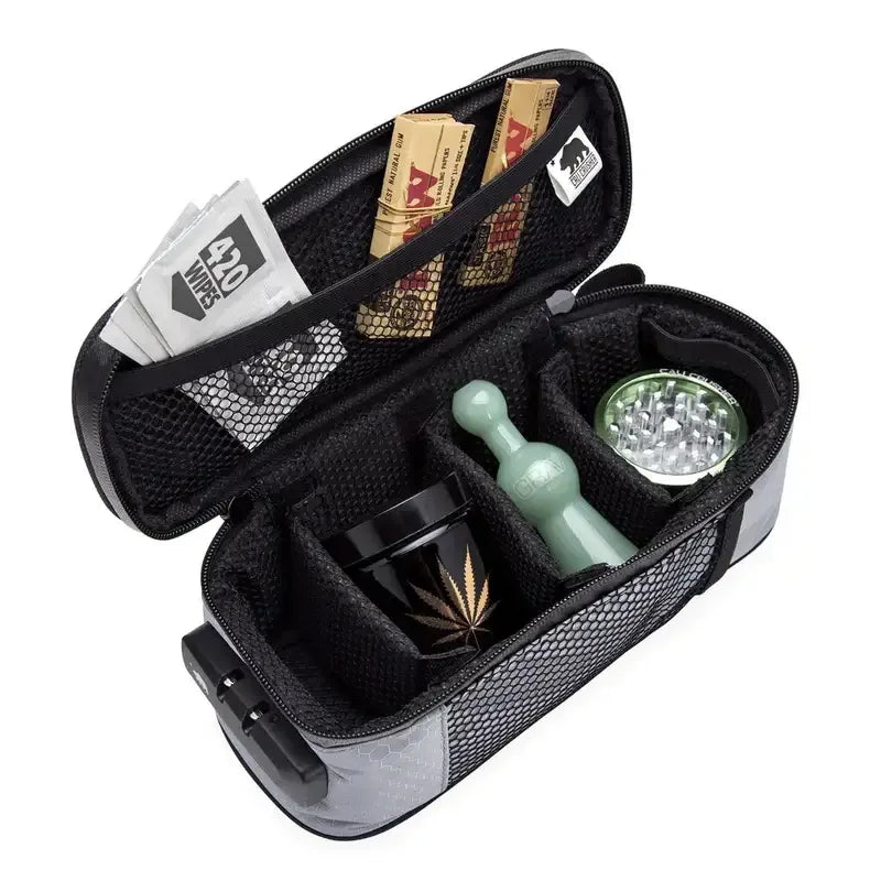 Eine geöffnete, geruchsdichte Reisetasche mit gepolsterten Fächern, die Blättchen, einen Grinder, eine Glaspfeife und ein Aufbewahrungsglas enthält.