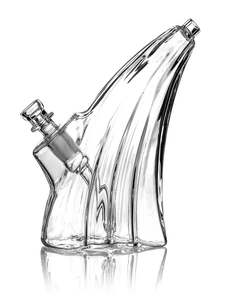 Ein eleganter, transparenter Glas-Bubbler mit einem markanten Wellendesign und einem schräg angesetzten Mundstück vor weißem Hintergrund.