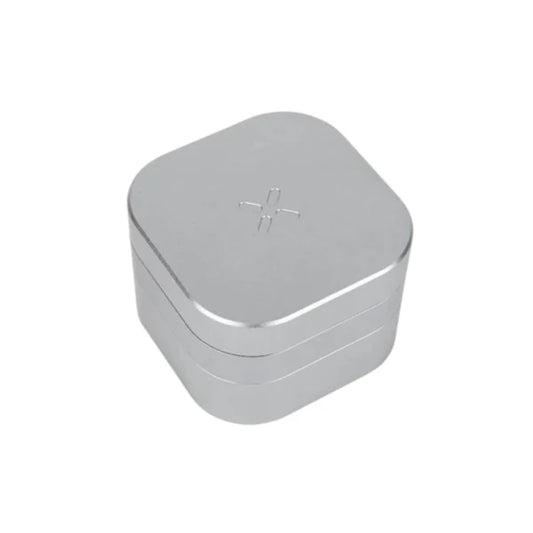 Ein quadratischer, silberner Kräutermahlwerk aus Metall mit abgerundeten Ecken und dem eingravierten PAX-Logo auf der Oberseite.