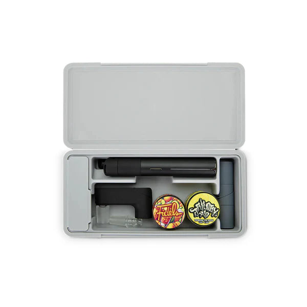 Ein geöffnetes silbernes Travel Case, ordentlich bestückt mit einem schwarzen Puffco Hot Knife, Konzentratbehältern und Glaszubehör in passgenauen Fächern.