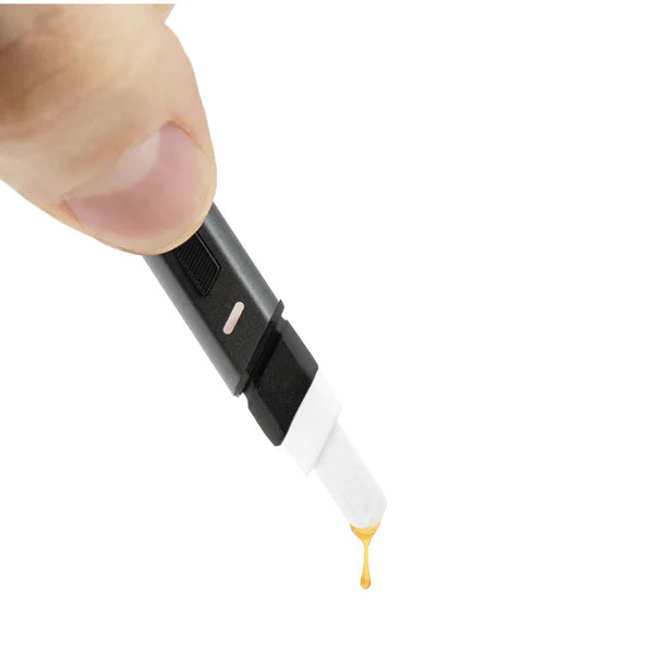 Eine Hand hält ein Puffco Hot Knife, während ein Tropfen goldenes Konzentrat von der erhitzten Keramikspitze gleitet.